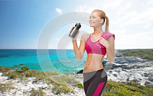 Sporty woman drinking water from sportsman bottle