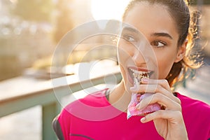 Sporty woman eating energy bar photo