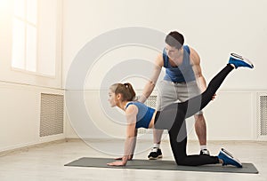 Sporty woman exercising with her personal trainer