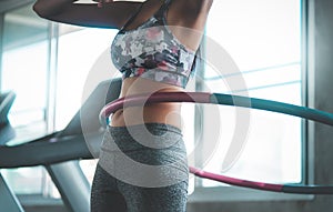 Sporty woman  exercising with Hula hoop in fitness gym for healthy lifestyle concept