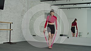 Sporty woman exercising with resistance band at gym