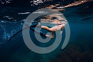 Sporty woman with fins swim in blue ocean