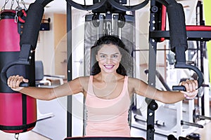 Sporty woman with a fitness machine in gym center