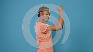 Sporty woman flexing trained arm muscles in front of camera