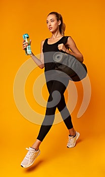 Sporty Woman Going To Gym Carrying Fitness Bag, Yellow Background