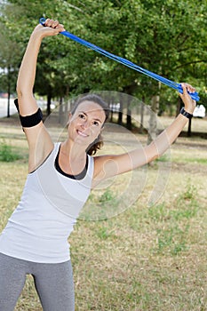 Sporty woman holding skipping rope above head