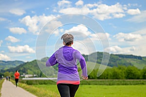 Sporty woman jogging away from the camera