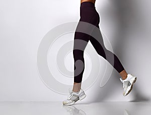 Sporty woman legs walking in sport wear on a white