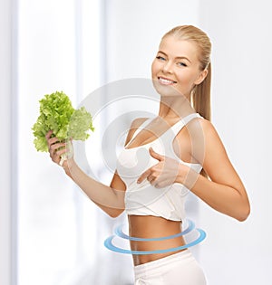 Sporty woman with lettuce showing abs