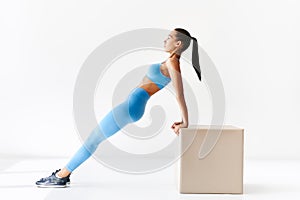 Sporty woman making reverse plank exercise on white background