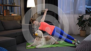Sporty woman making sidestand exercise with dog