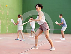 Sporty woman performing basic strokes during paleta fronton group training