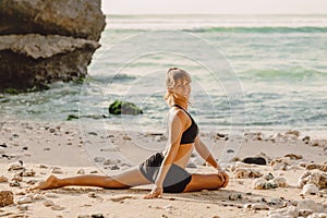 Sporty woman practice yoga at ocean coast with sunset