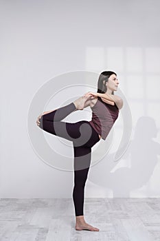 Sporty woman practicing yoga on white background