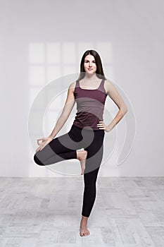 Sporty woman practicing yoga on white background