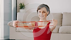 Sporty woman in red costume doing exercises with the fitness band