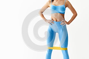 Sporty woman with resistance band loop workouts on white background with copy space