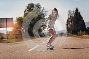 Sporty woman riding on the skateboard on the road