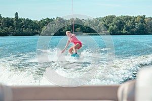 Sporty woman riding a wakeboard and performing tricks