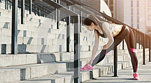 Sporty woman runner stretching before training