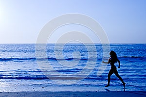 Sporty woman running along beach