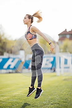 Fitness sporty woman running and jumping in the park