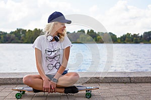 Sporty woman sitting on longboard