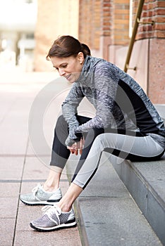 Sporty woman sitting outside resting after workout