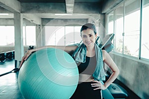 Sporty Woman in Sportswear is Resting Tired During Exercise While Holding Pilates Ball in Fitness Gym, Sport Asian Woman