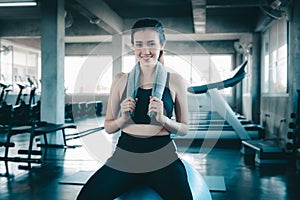 Sporty Woman in Sportswear is Resting Tired During Exercise on Pilates Ball in Fitness Gym, Smiling Asian Woman Exercising Yoga