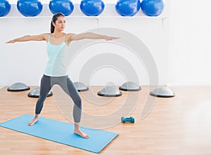 Sporty woman stretching hands in fitness studio