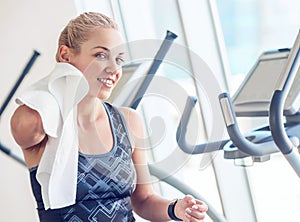 Sporty woman with towel in gym after training