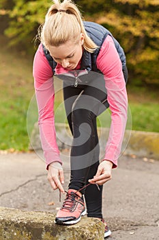 Sporty woman tying her shoes