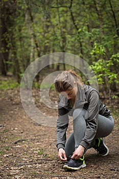 Sporty woman tying shoes