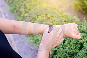 Sporty woman using smart watch for running and checking device at outdoor during sunrise in the morning