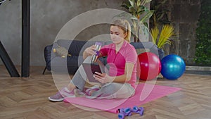 Sporty woman video conferencing with fitness trainer