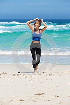 Sporty woman walking barefoot on beach