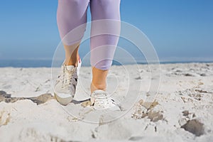 Sporty womans feet on the sand