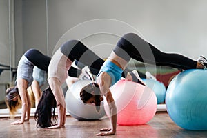 Sporty women doing pilates exercise on fit-balls