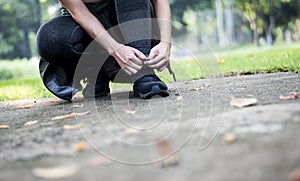 Sporty women are tied with running shoes to run exercise in the morning. Portrait of beautiful Women exercising in the park on