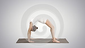 Sporty yoga girl performing Chakrasana Urdva Dhanurasana Wheel Pose on gradient background.