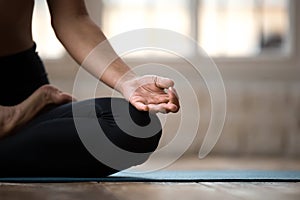 Sporty yogi woman practicing yoga, doing Ardha Padmasana exercis photo