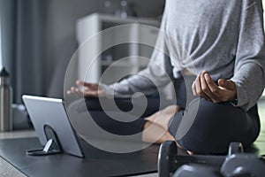 Sporty young Asian woman exercising at home, watching fitness video on Internet or having online fitness class