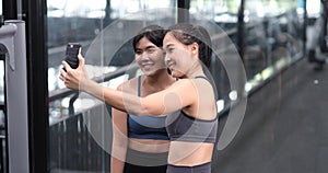Sporty young asian women with friends taking picture of her friend using mobile phone