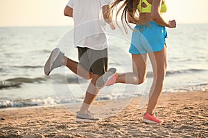 Sporty young couple running on sea beach