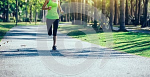 young fitness woman running at tropical park