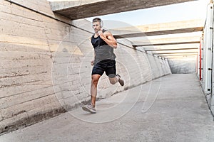 Sporty young man jogging with music from headphones, morning routine. Healthy lifestyle concept