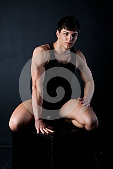 Sporty young man sits in black t-shirt