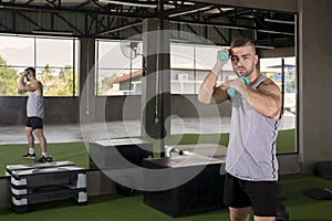 Sporty young man training with dumbbells with copy space. sport concept