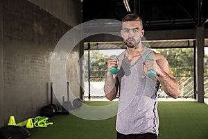 Sporty young man training with dumbbells with copy space. sport concept